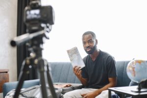 African male blogger recording vlog on digital camera
