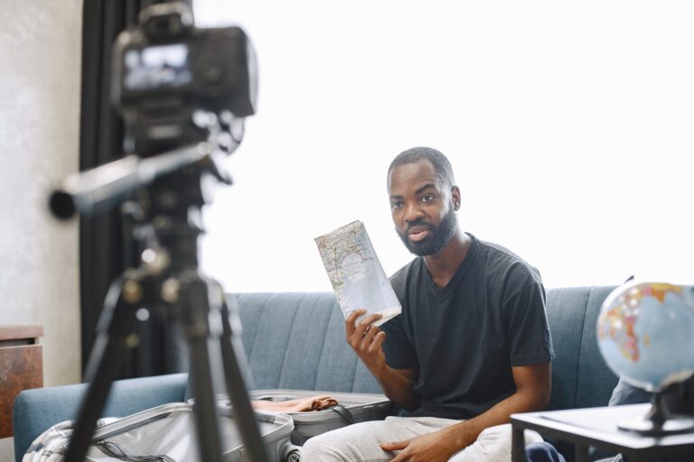 African male blogger recording vlog on digital camera