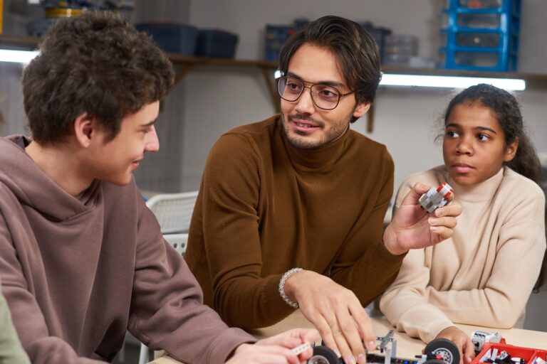Man teaching children robotics