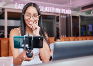 Social media, influencer and phone with a woman recording content and live streaming subscription s